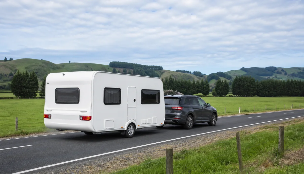 An SUV towing a caravan along an open country road