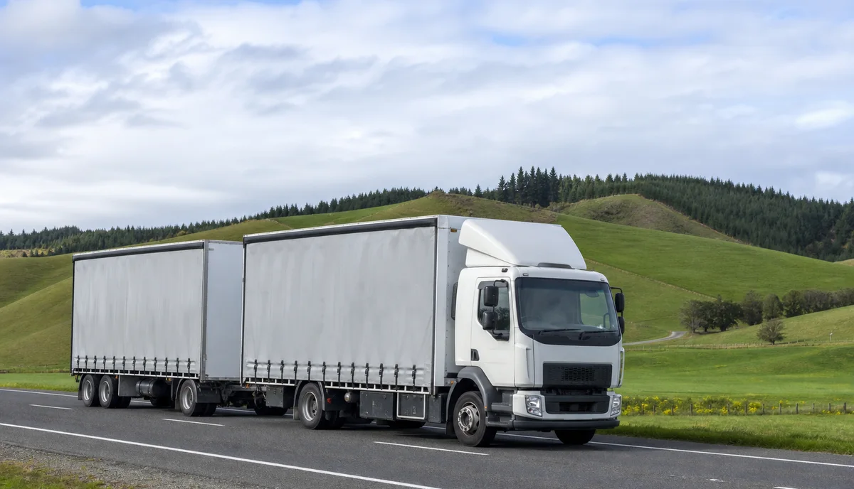 A curtain sider truck and trailer unit on an open New Zealand highway
